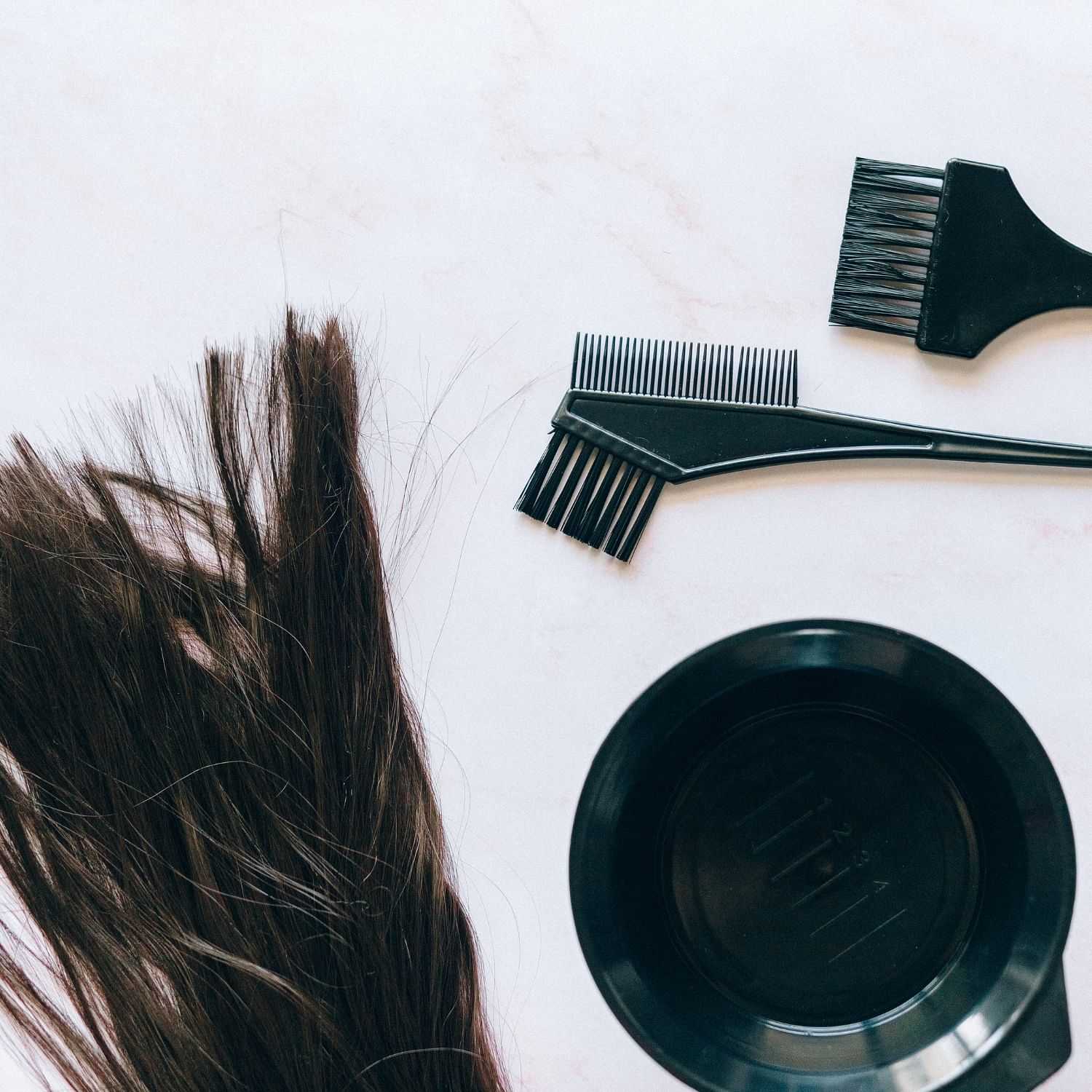 Hair color tools and dark brown hair on a table ready to go.